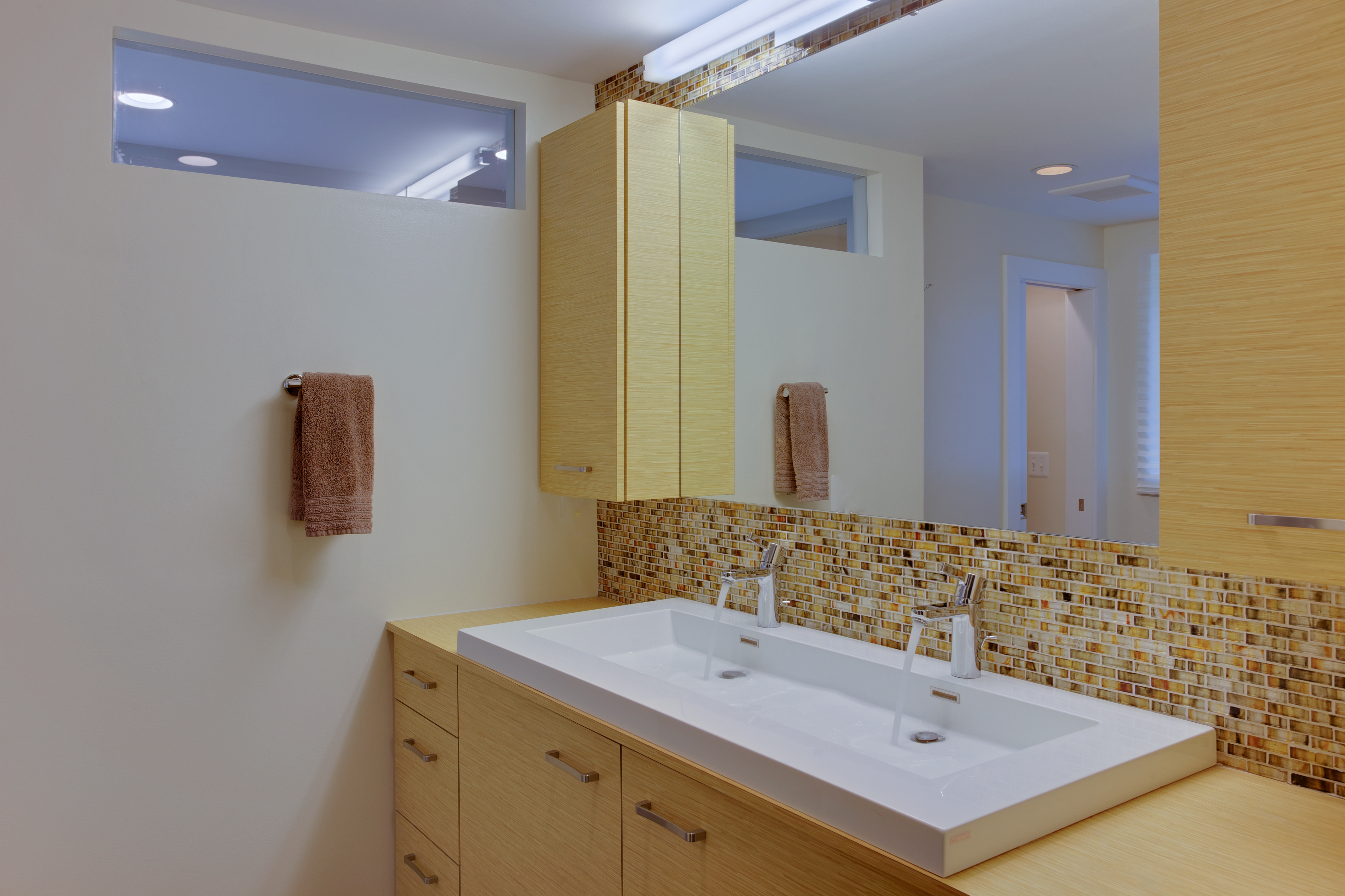 Bathroom with double vanity and yellow, wood cabinetry - view 1